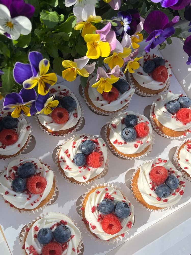 Cupcakes topped with cream and fresh berries